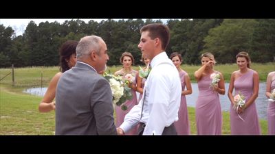 a man in a suit standing next to a woman in a pink dress