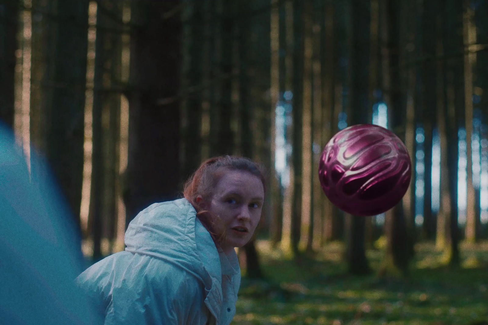 a woman throwing a ball in the woods