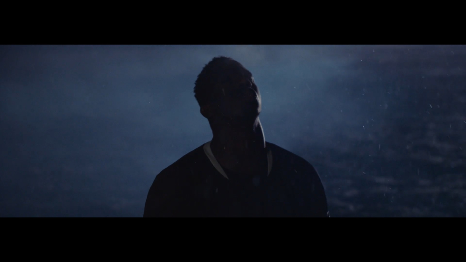 a man standing in the rain at night