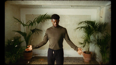 a man standing in a room with potted plants