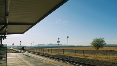 a train station with a person standing on the platform