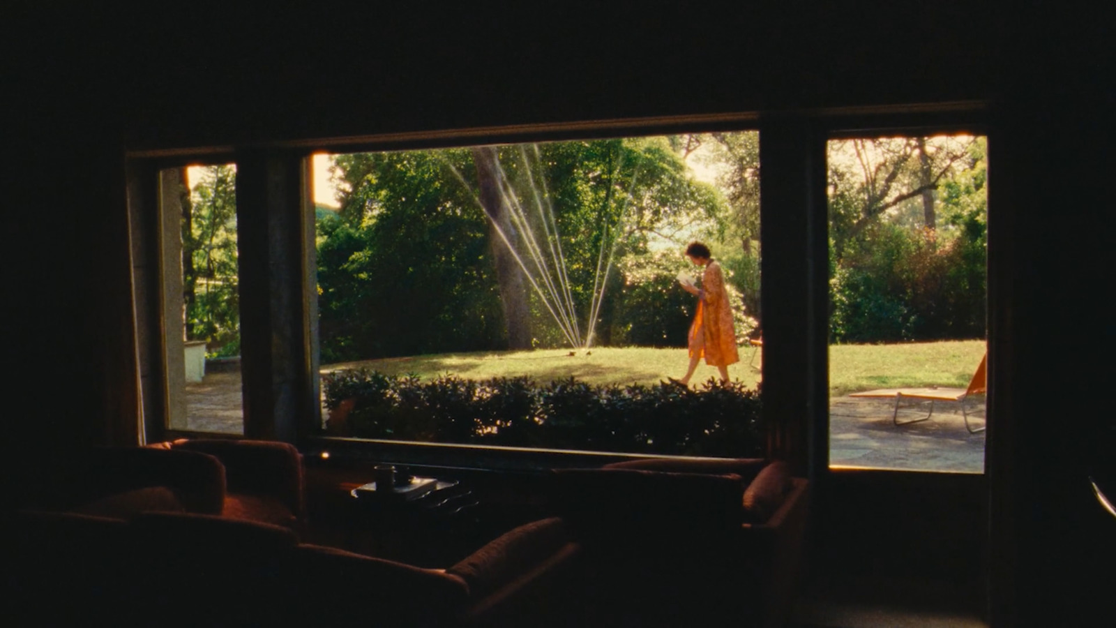 a woman standing in a living room next to a window