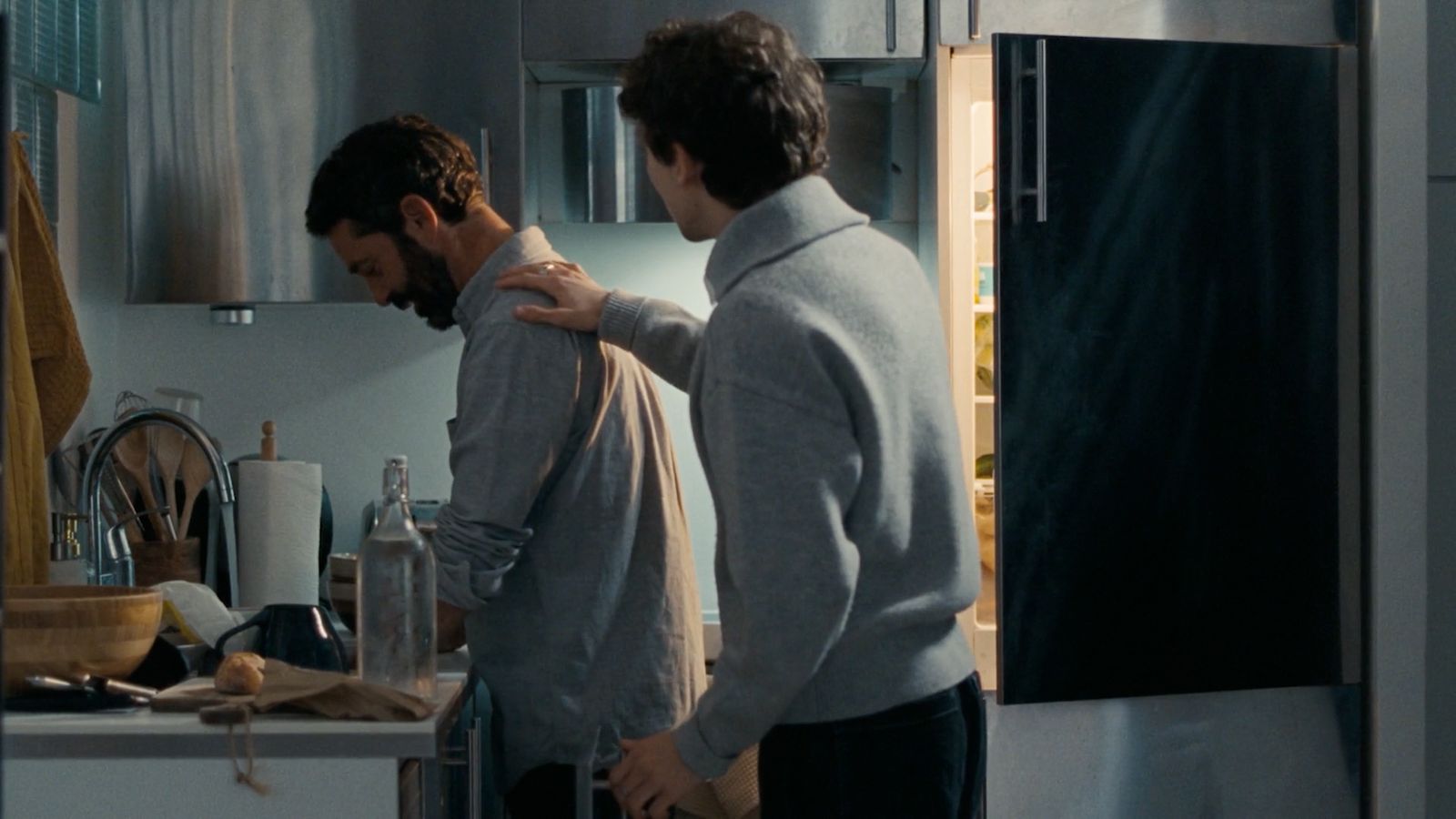 a couple of men standing next to each other in a kitchen