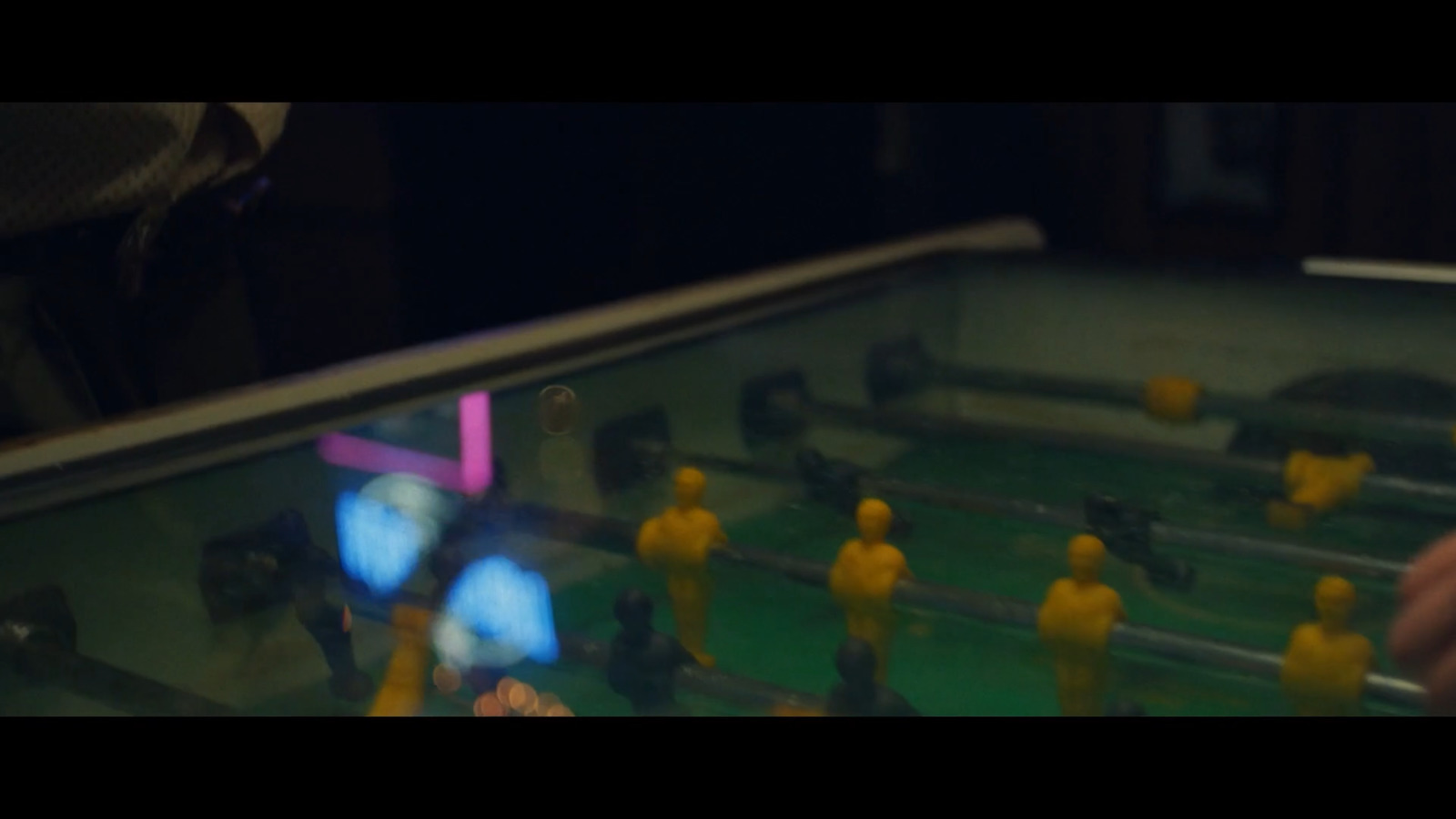 a close up of a foosball table with people playing foosball