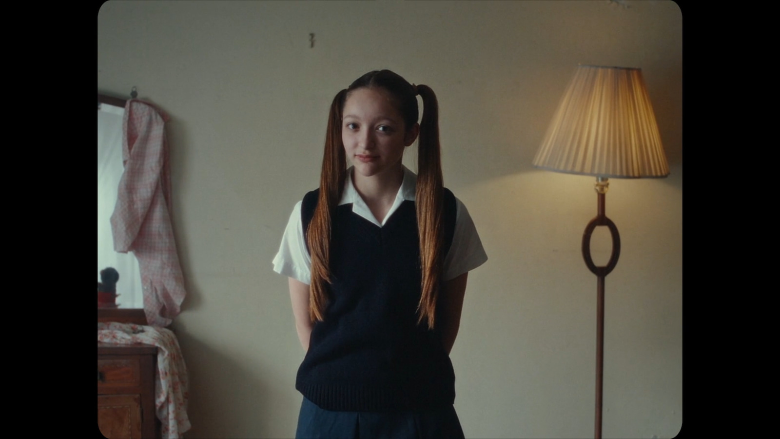 a girl with long hair standing next to a lamp