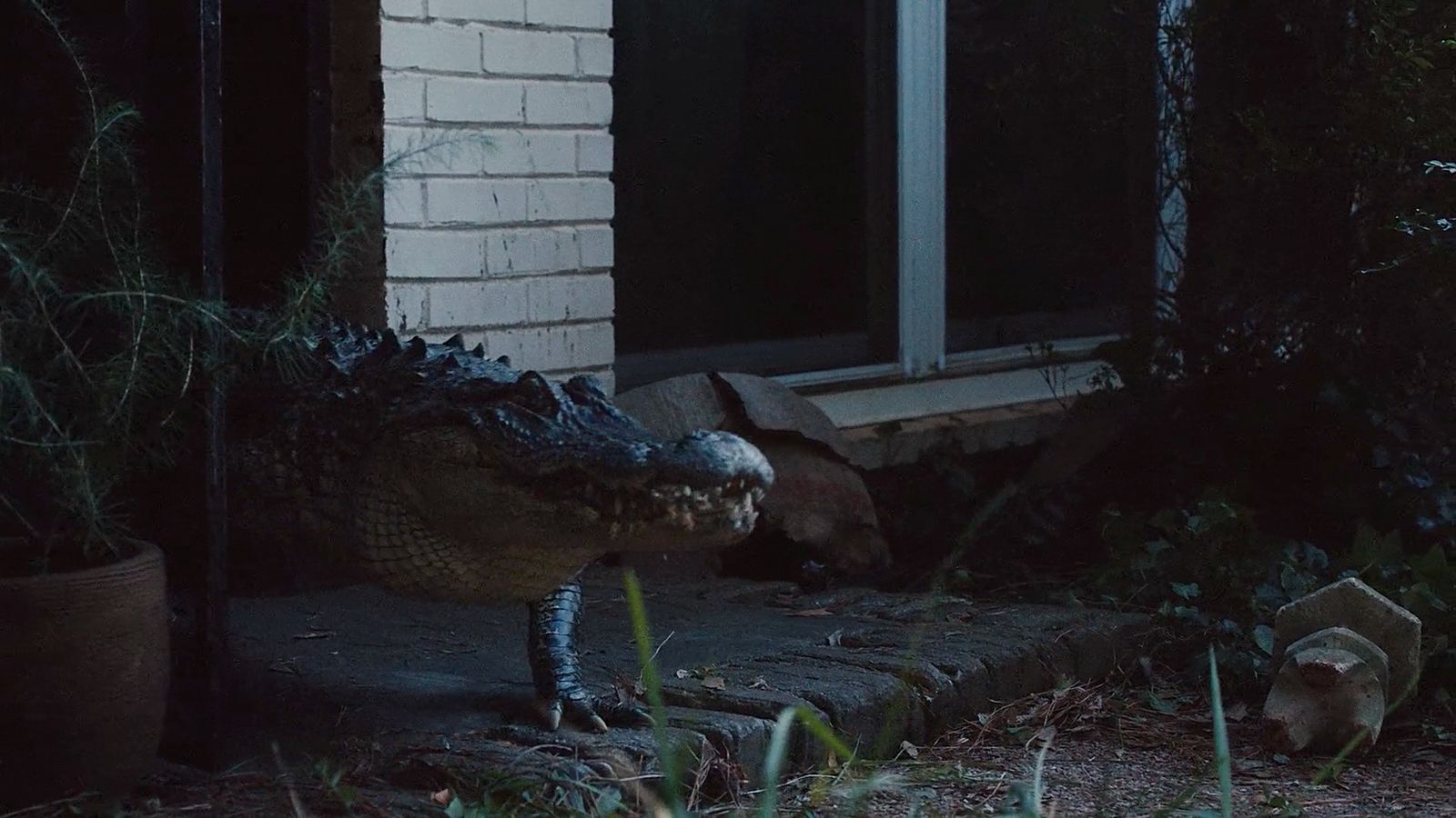 a large alligator standing next to a brick building