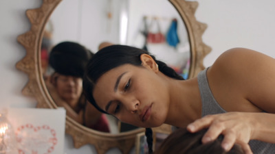 a woman getting her hair styled in front of a mirror