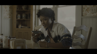 a woman sitting at a table looking at a cell phone