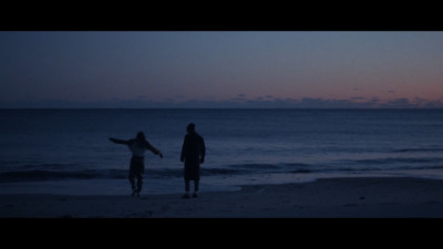 a couple of people standing on top of a beach