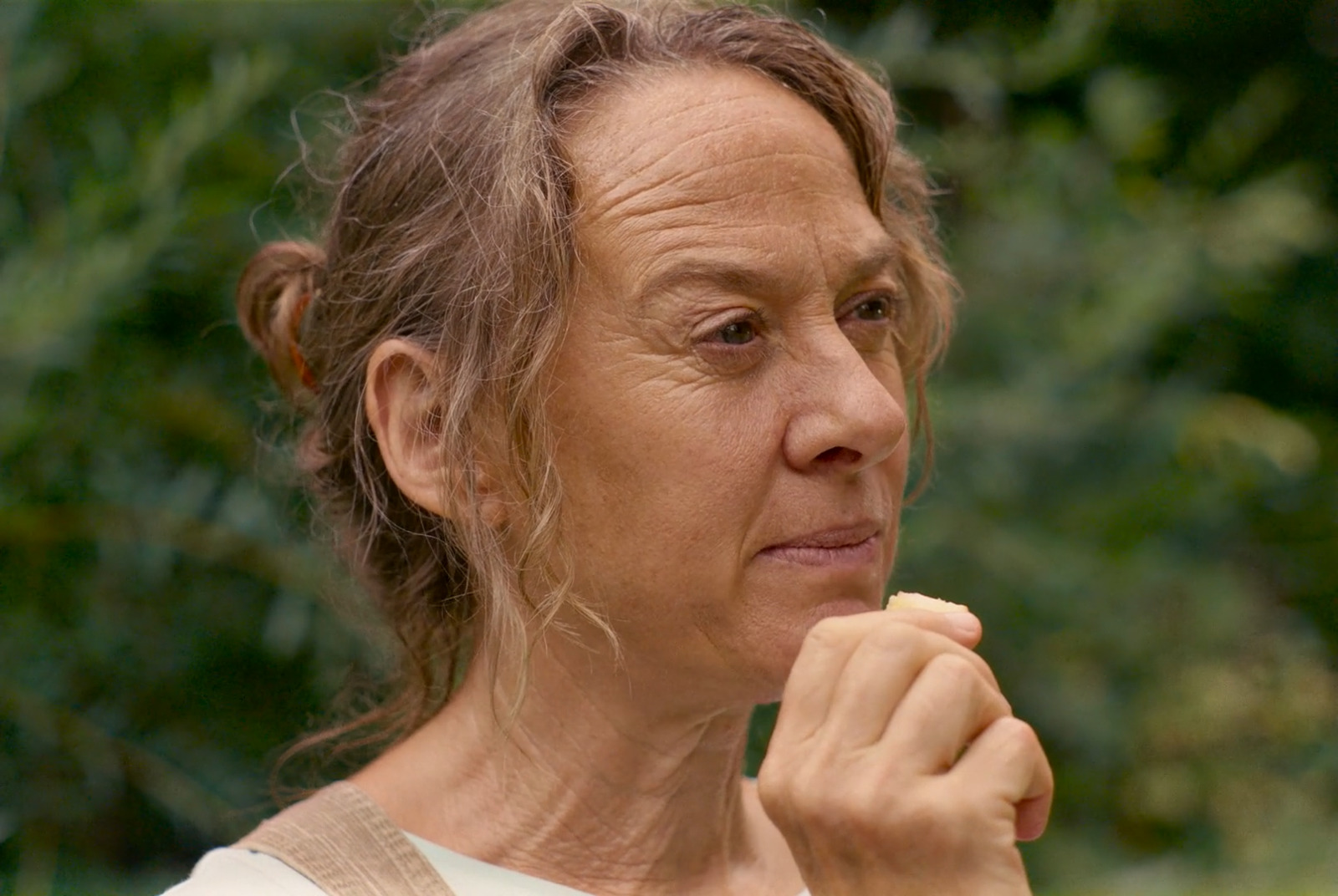 a woman holding a piece of food in her hand