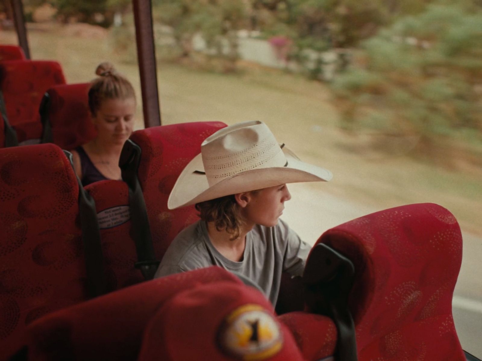 a man in a cowboy hat sitting on a bus