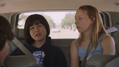 two girls sitting in the back seat of a car