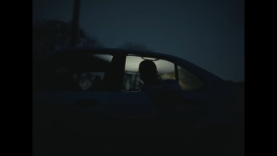 a person sitting in a car in the dark