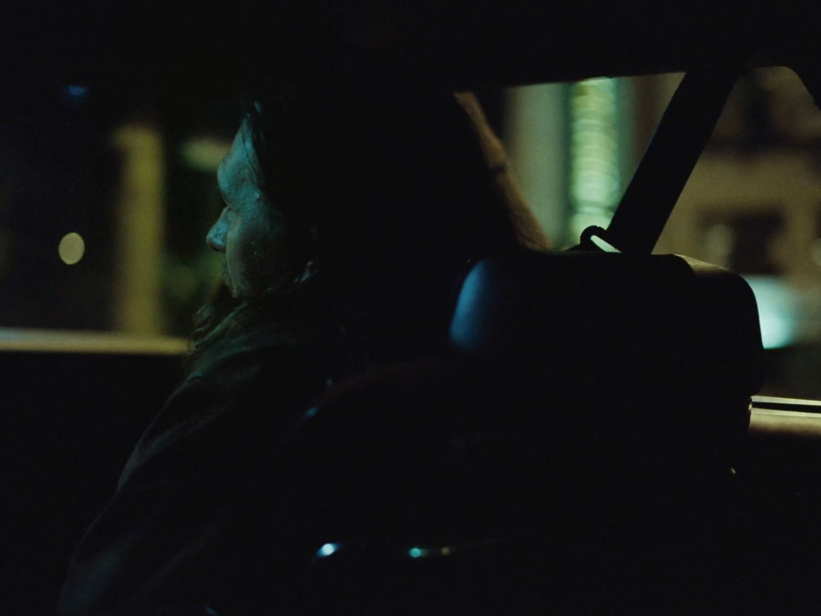 a man driving a car at night in the dark