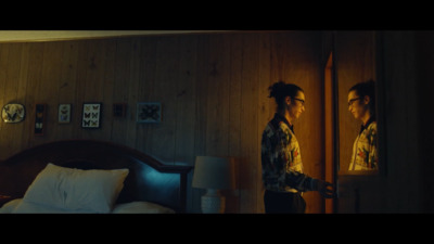 a man standing in front of a mirror in a bedroom