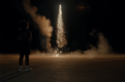 a person standing in the middle of a street watching fireworks