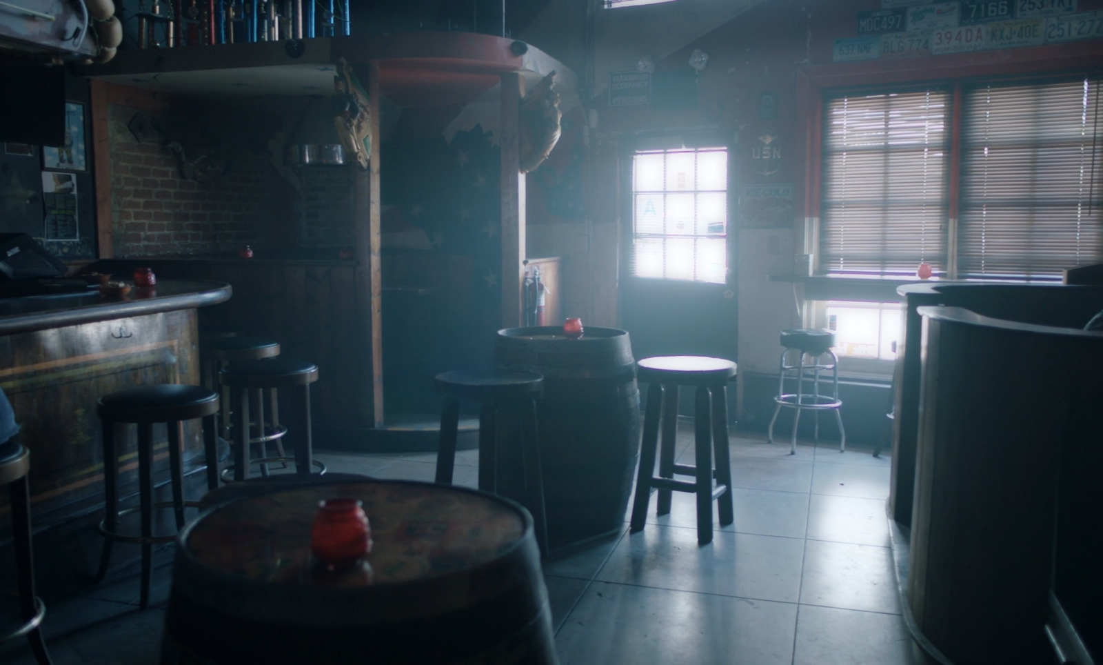 a dimly lit room with stools and a bar