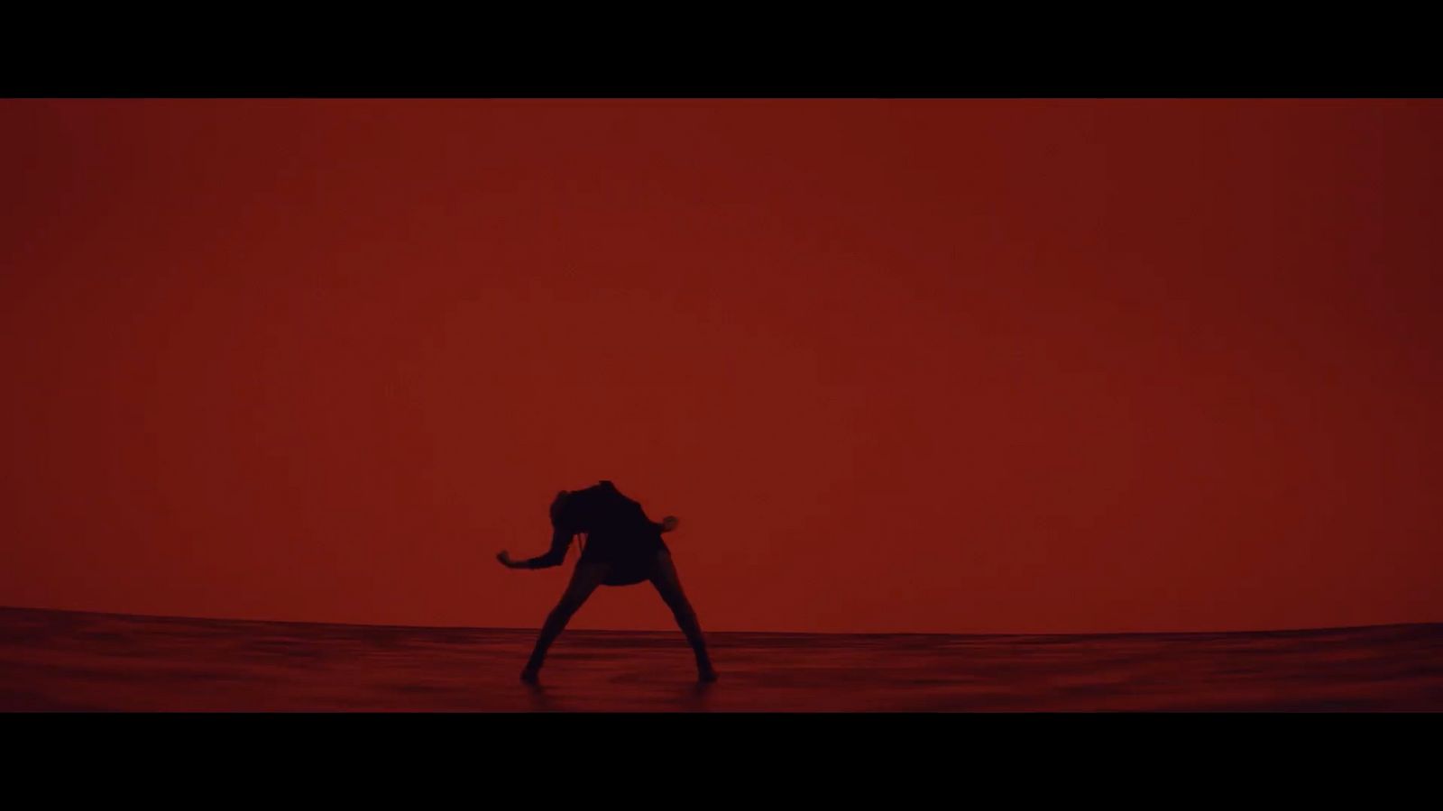 a person standing in the water with a red background