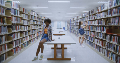 two women sitting at a table in a library