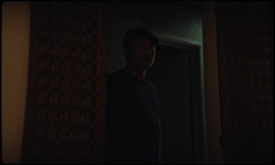 a man standing in a doorway in a dark room