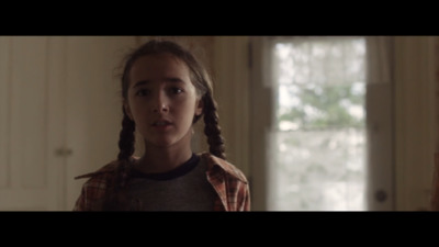 a young girl with braids standing in a room