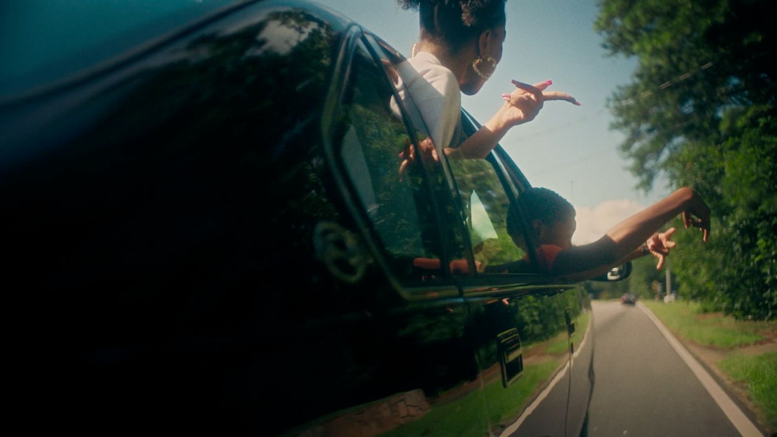 a woman sitting on the side of a car