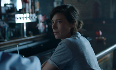 a woman sitting at a bar looking off into the distance