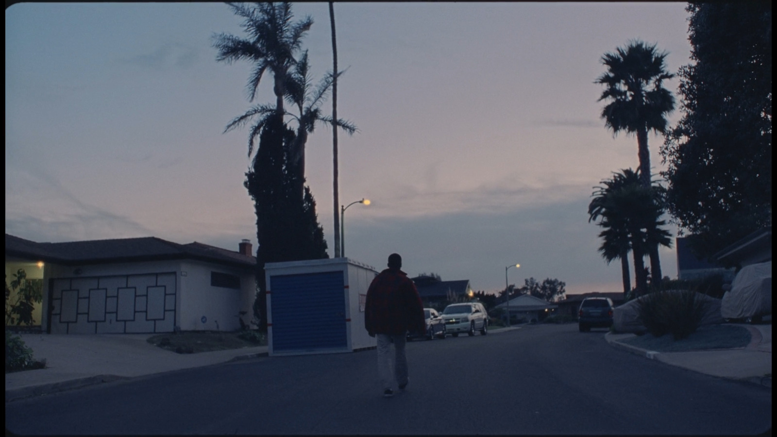 a person walking down a street at dusk