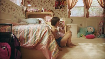 a girl sitting on a bed reading a book