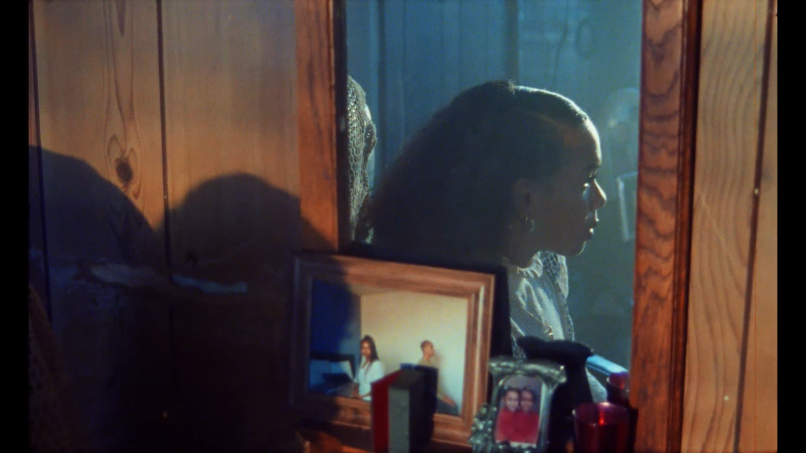 a woman looking in a mirror with a picture of herself