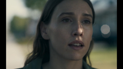 a close up of a person wearing a green jacket