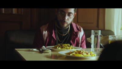 a man sitting at a table in front of a plate of food