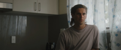 a man standing in a kitchen next to a window