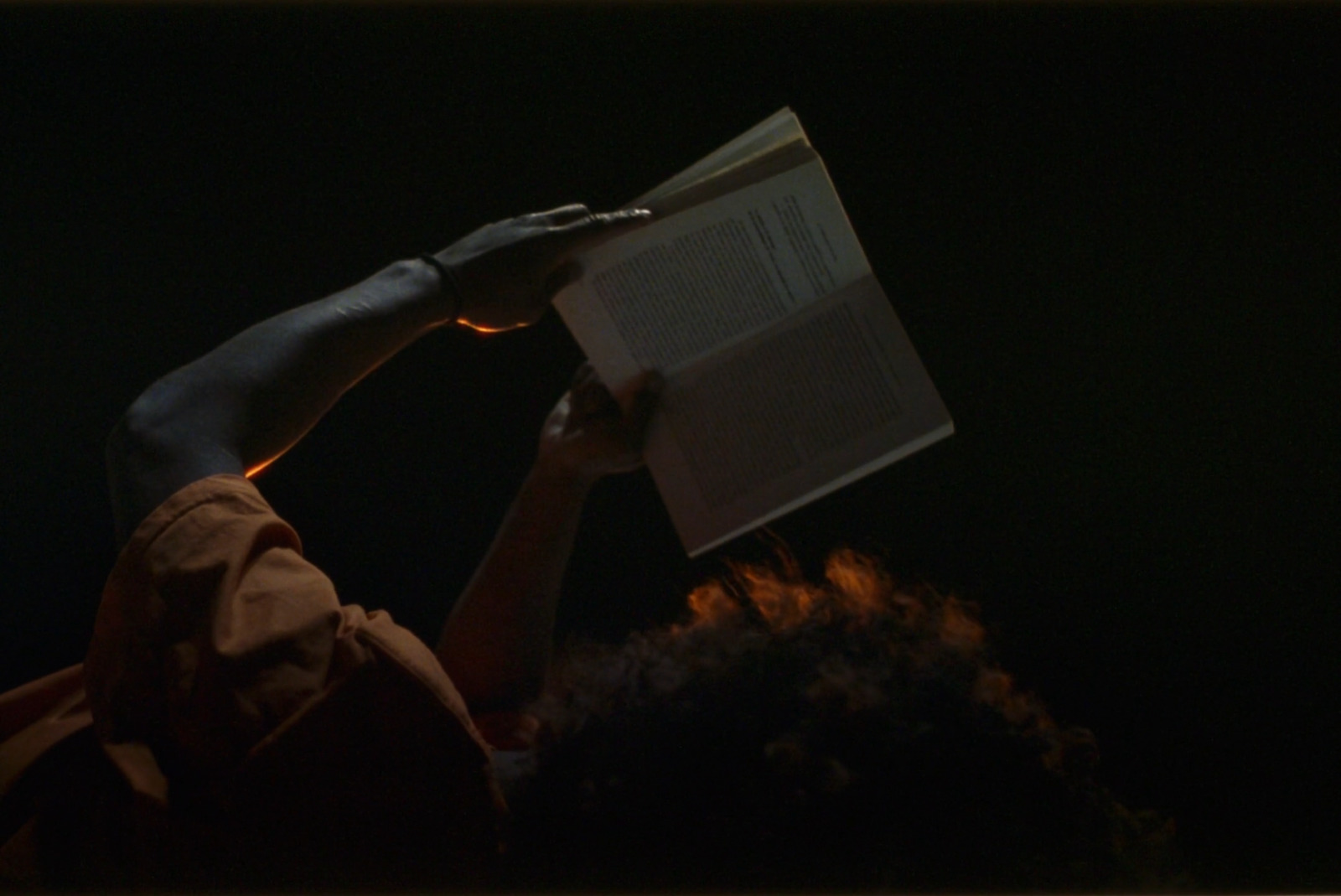 a person reading a book in the dark