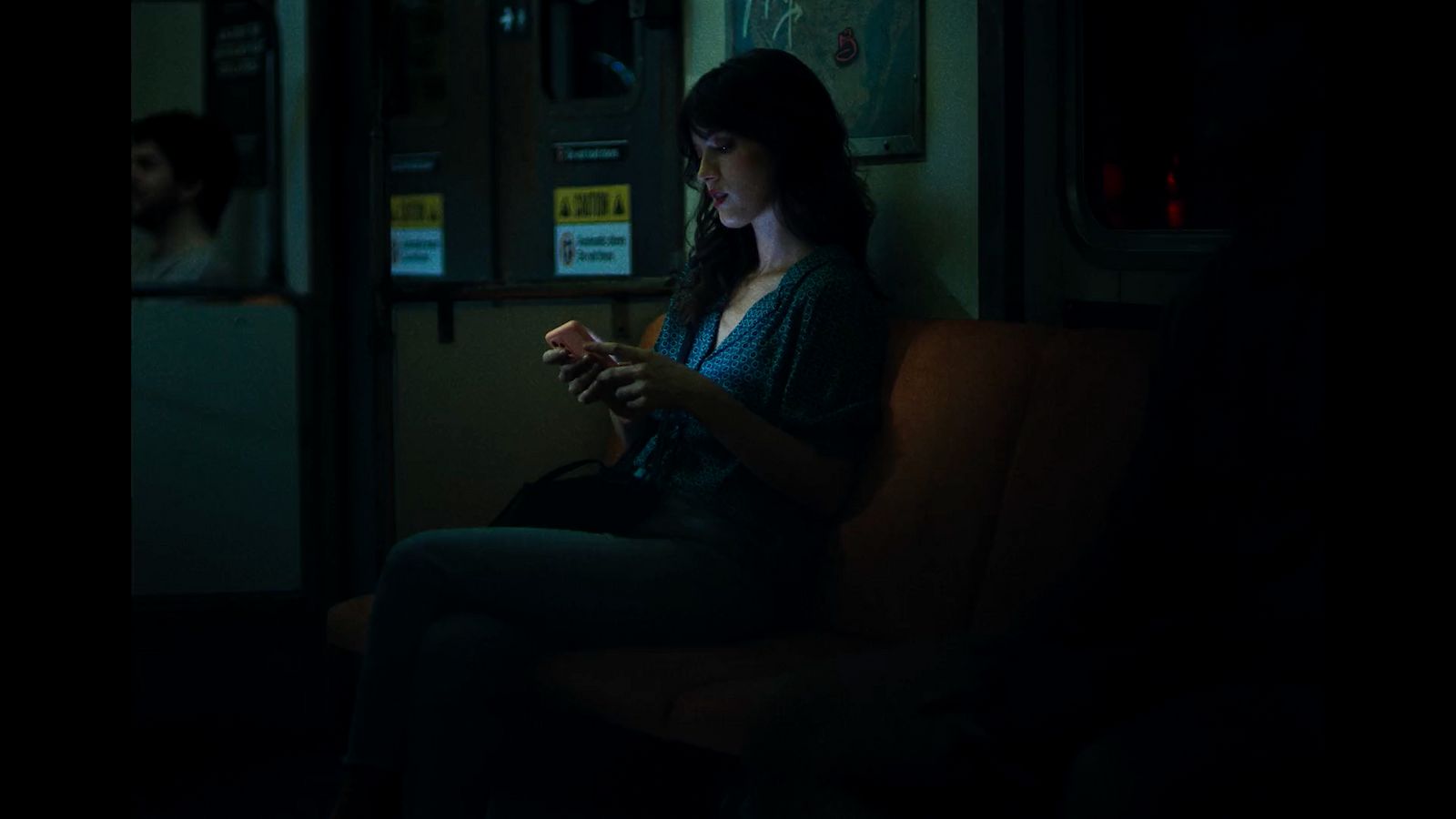 a woman sitting on a train looking at her phone