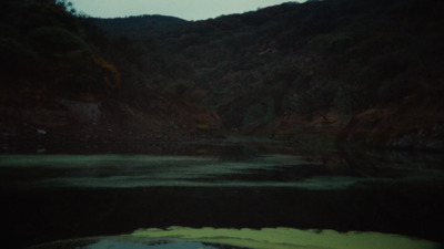 a body of water with a mountain in the background