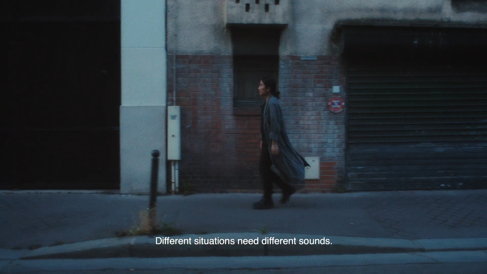 a man walking down a street next to a building