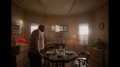 a man standing in a dining room next to a table