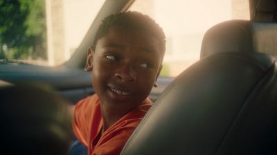 a young boy sitting in the back seat of a car