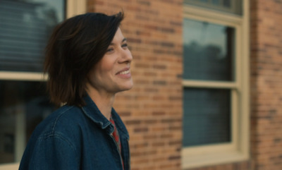 a woman standing in front of a brick building