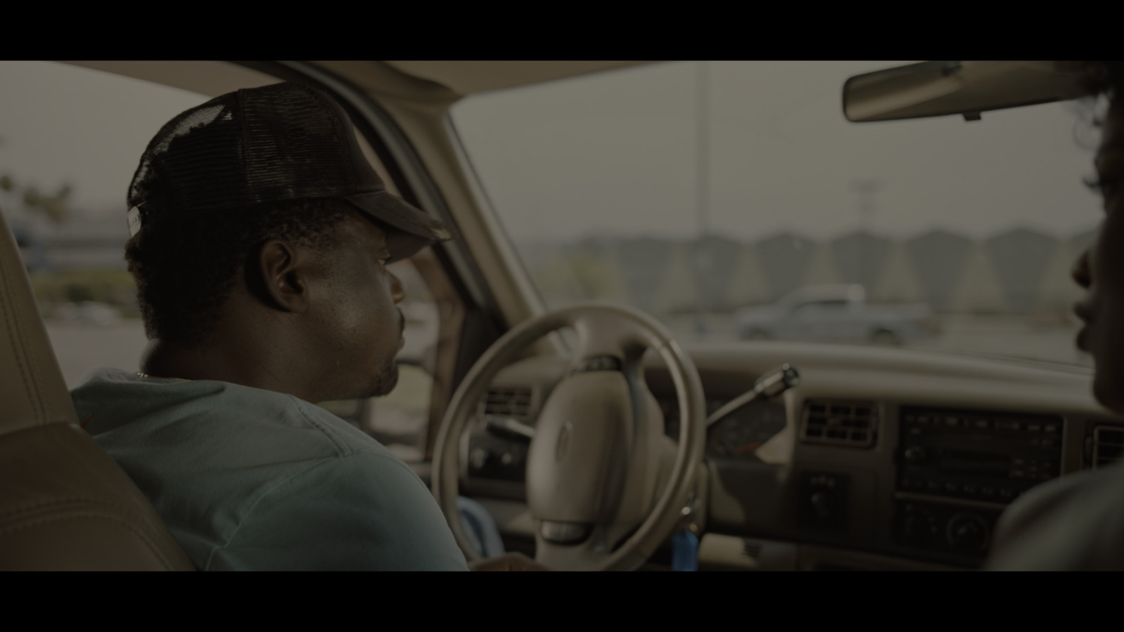 a man sitting in a car talking to another man