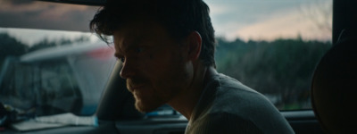 a man sitting in a car looking out the window