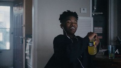 a man holding a bottle of water and listening to headphones