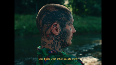 a man with tattoos on his face and neck