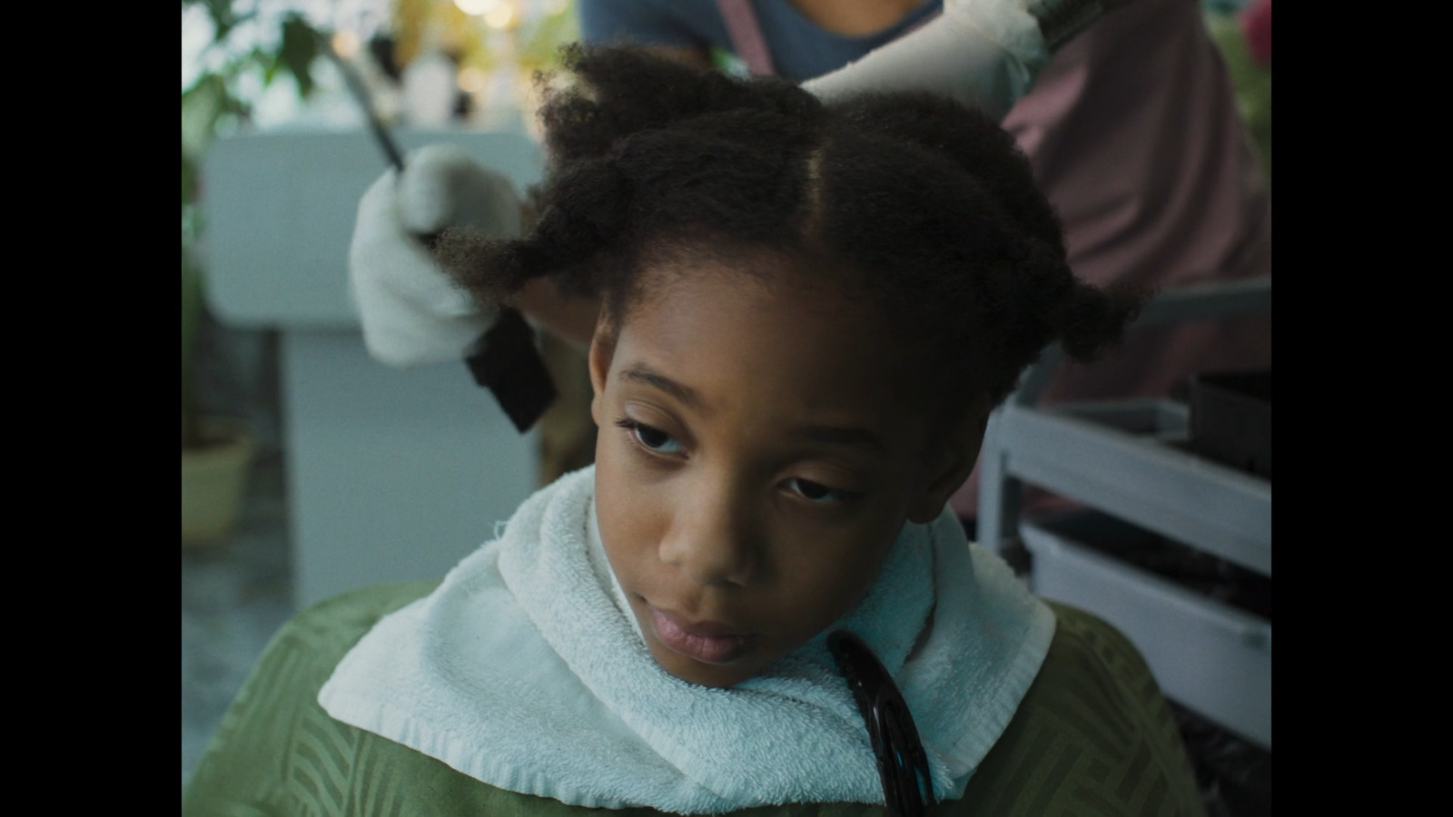 a young girl getting her hair styled by a hair stylist