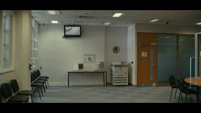 a room with chairs, a table and a television