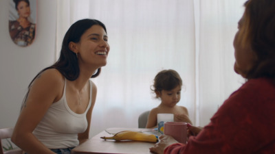 a woman sitting at a table next to a little girl