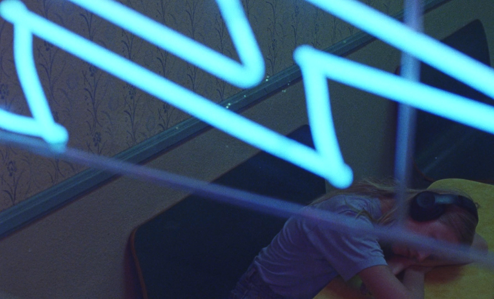 a young girl sitting on a yellow chair in a room