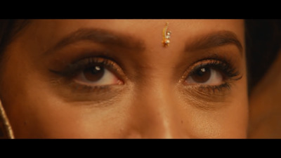 a close up of a woman's eye with gold jewelry