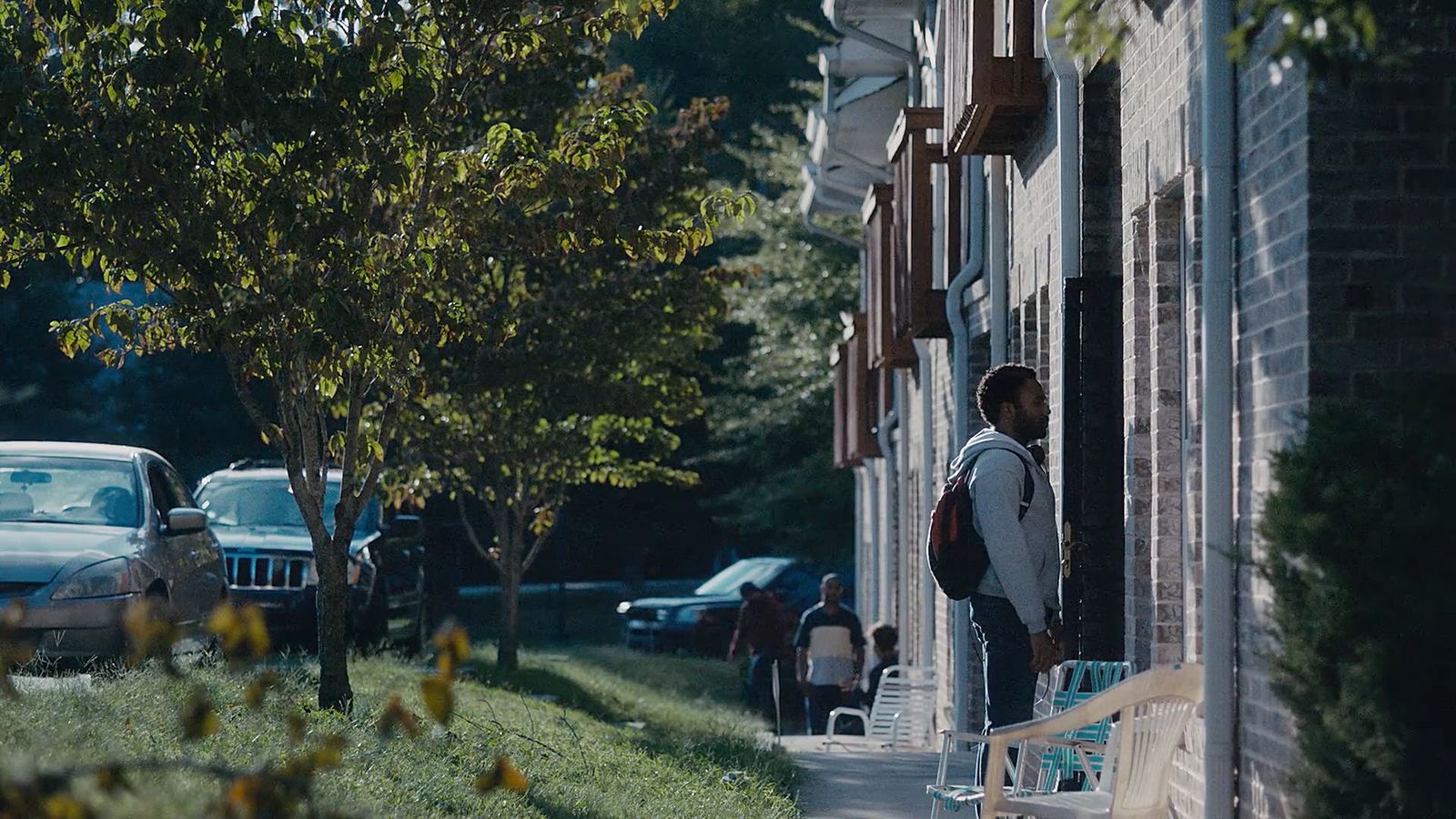 a man standing on a sidewalk next to a building